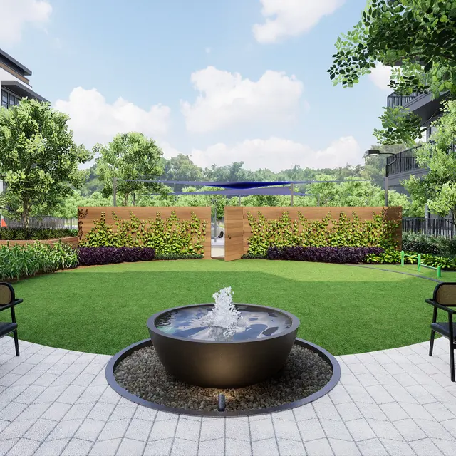 A modern apartment courtyard featuring a circular fountain, surrounded by seating areas and lush greenery.