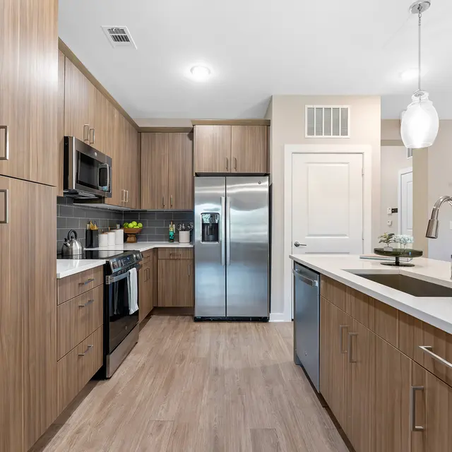 Modern Kitchen Interior A modern kitchen featuring wooden cabinetry, stainless steel appliances, and a spacious island with seating.