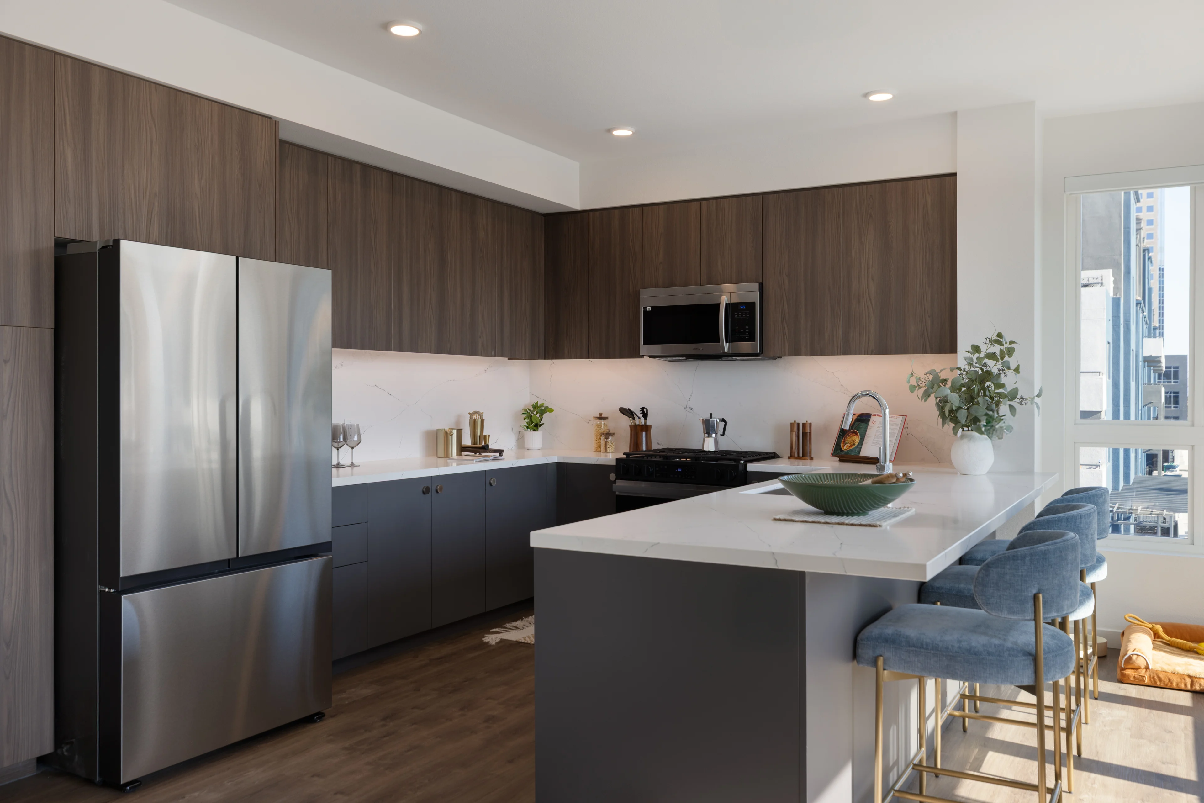 Modern Kitchen Design A modern kitchen featuring dark wood cabinetry, stainless steel appliances, and a large island with bar stools.