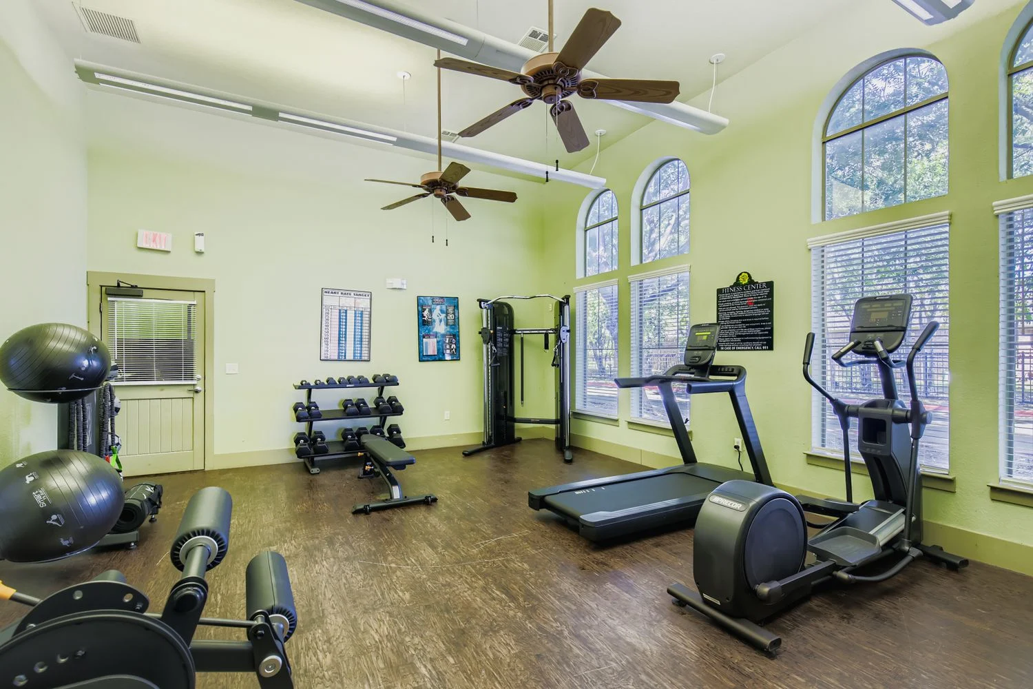 Indoor Gym with Exercise Equipment An indoor gym with exercise equipment and ample natural light coming from large windows.