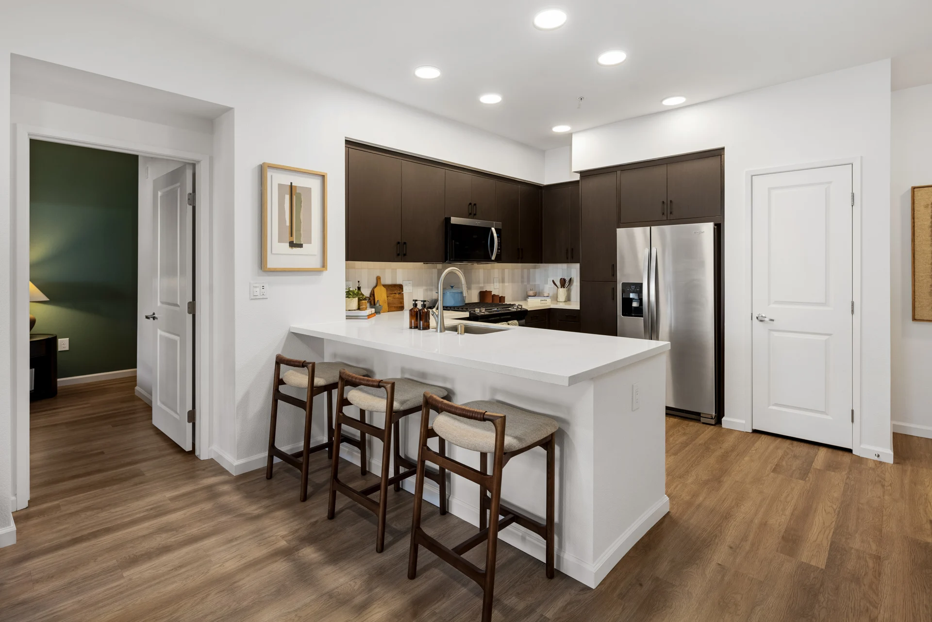 Contemporary Kitchen Design A modern kitchen with dark cabinetry, stainless steel appliances, and a spacious island with bar stools.