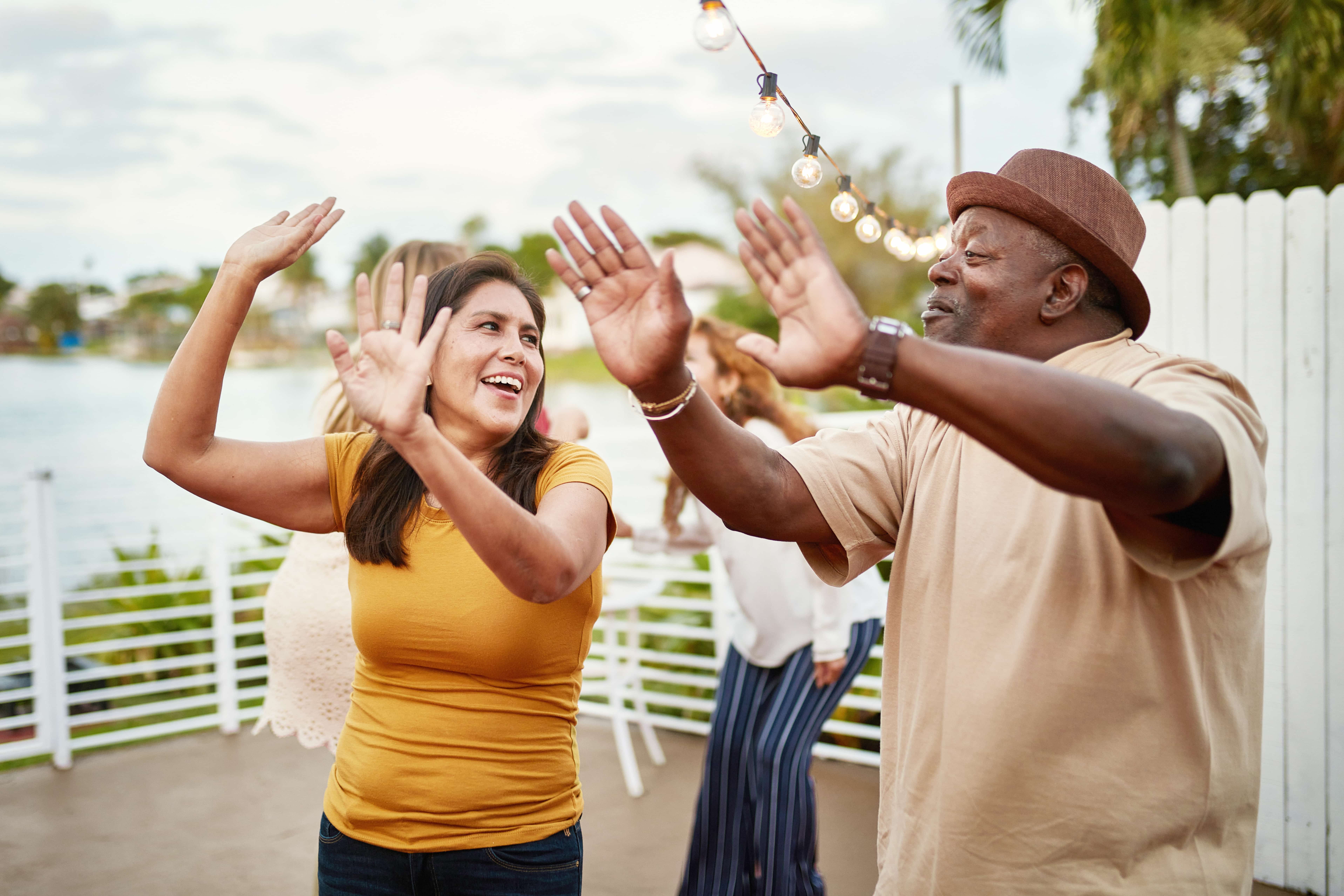 Dancing at a Social Gathering Two people dancing joyfully outdoors at a social gathering.