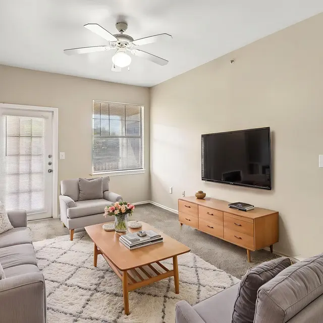 Modern Living Room Design Cozy living room with grey sofas, a wooden coffee table, and a TV on the wall.