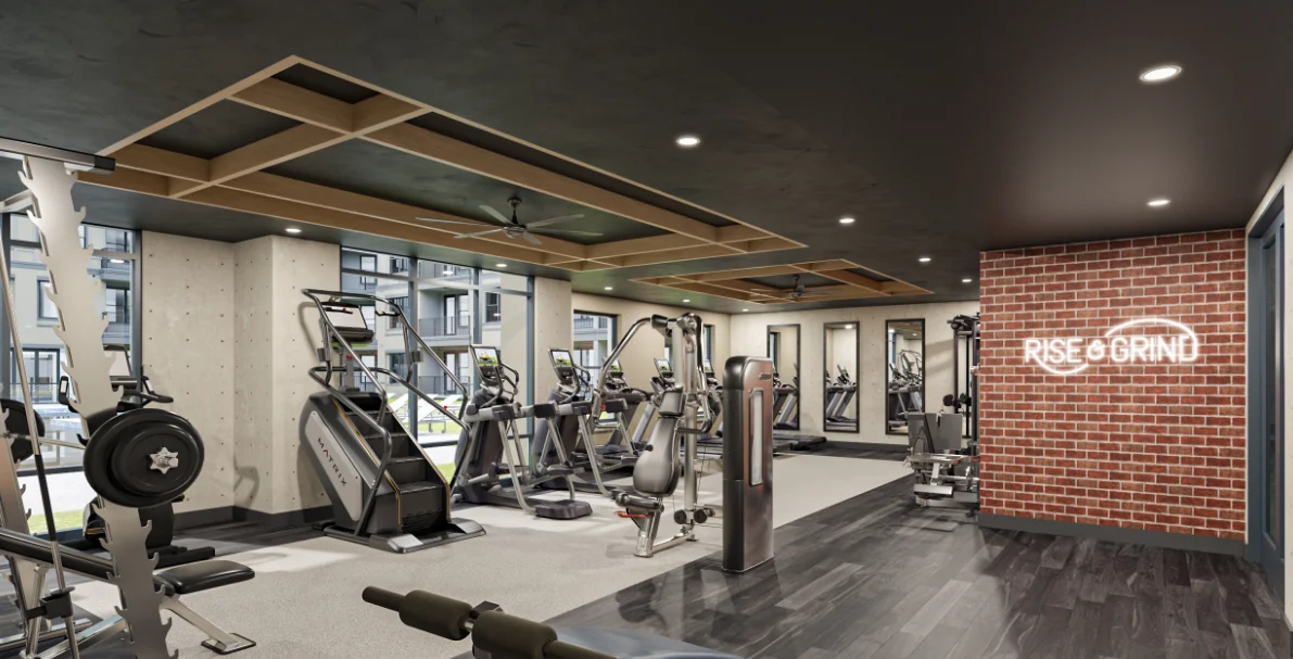 Modern Gym Interior A modern gym interior featuring fitness equipment, a brick wall with the text 'RISE & GRIND', large windows, and a sleek design.