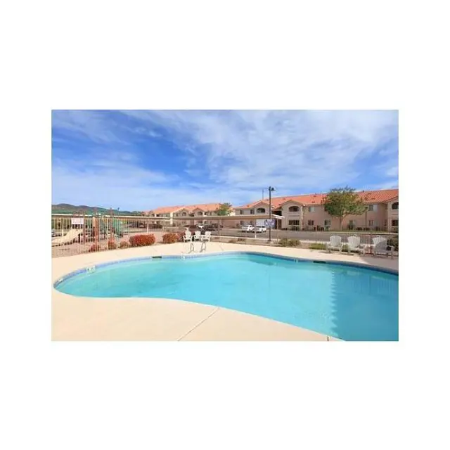 Swimming Pool Outdoor Area A clear swimming pool surrounded by lounge chairs and a view of residential buildings under a blue sky.